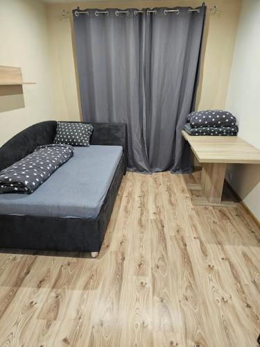 Habitación con cama, mesa y cortina en 3 izbový byt, en Prievidza