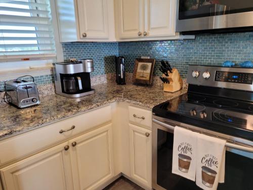 a kitchen with white cabinets and a stove top oven at Beach Condo on Okaloosa Island Emerald Isle 6th floor 2 bedrooms and murphy bed in Fort Walton Beach