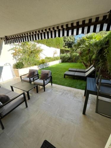 un patio avec des chaises et des tables ainsi qu'un jardin dans l'établissement T2 avec Terrasse et Jardin, à Cannes