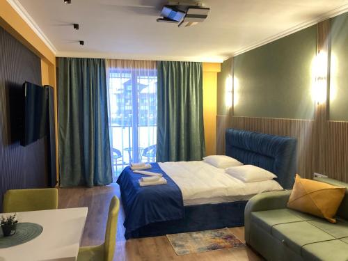 a hotel room with a bed and a couch at Brand new apartment near Gondola in Gudauri