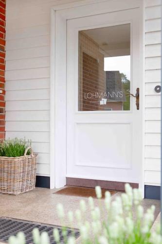 a white door on a house with a sign on it at Lohmann's Ferienwohnung in Garstedt