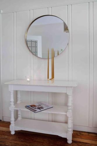 a white shelf with a mirror and a magazine on it at Lohmann's Ferienwohnung in Garstedt