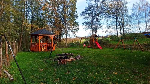 a park with a playground with a gazebo at Las Lorien - wynajem domków letniskowych in Roczyny