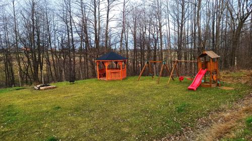a playground with two play equipment in the grass at Las Lorien - wynajem domków letniskowych in Roczyny