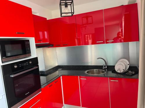 a red kitchen with red cabinets and a sink at Republique Lounge in Fort-de-France