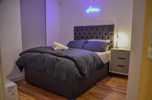 1 bedroom Flat in Manchester في مانشستر: غرفة نوم مع سرير مع جدار أرجواني