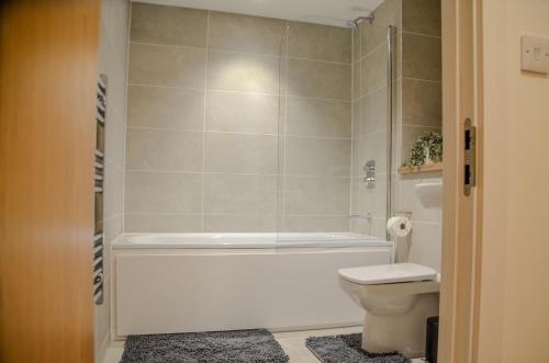 1 bedroom Flat in Manchester في مانشستر: حمام مع حوض استحمام ومرحاض