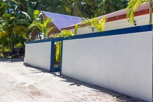 a white wall with a blue door on it at Captal Beach Villa in Mathiveri