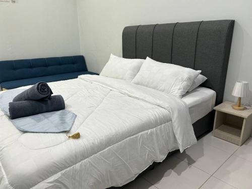 a bedroom with a large white bed with a blue headboard at Havengate Homestay in Butterworth