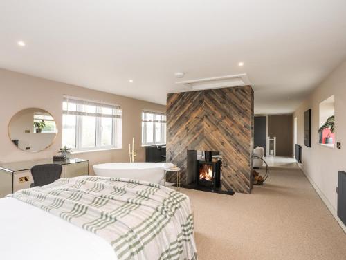 a bedroom with a bed and a fireplace at The Hayloft in Amlwch