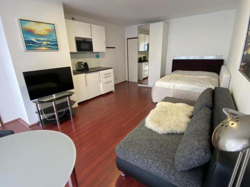 - un salon avec un canapé et un lit dans l'établissement Friesenwall Apartments, à Cologne