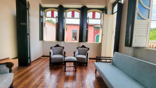 two chairs and a couch in a room with windows at Casa de Izaura in Lençóis