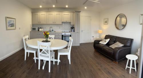 a kitchen and a living room with a table and a couch at Park Avenue Apartment in Newcastle