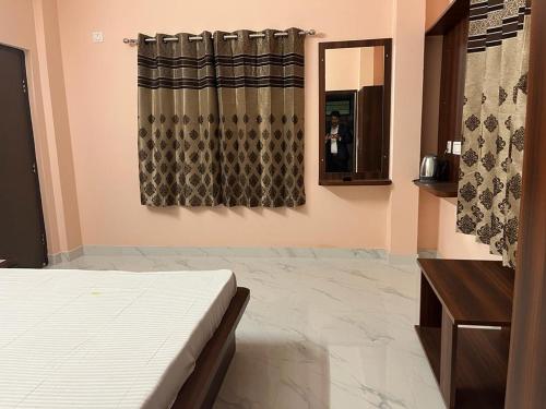een slaapkamer met een bed en een spiegel bij Sumangal Homestay in kolkata