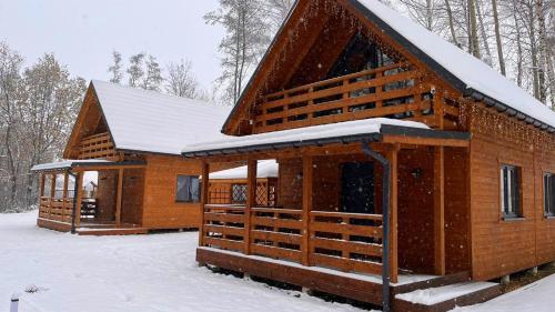 a log cabin with snow on the roof at Las Lorien - wynajem domków letniskowych in Roczyny