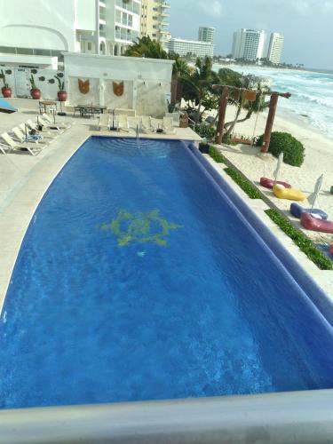 a large blue swimming pool next to the beach at Ocean Seaview Dream condo next to clubs in Cancún