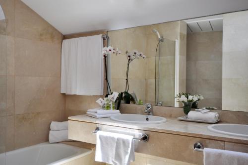 y baño con 2 lavabos, bañera y espejo. en Suite Prado, en Madrid