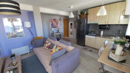 a living room with a couch and a kitchen at Mi casita in A Coruña