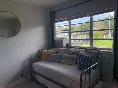 a room with a bed with pillows and a window at Walk to the beach, Studio, with Pool and FREE Parking in Hallandale Beach
