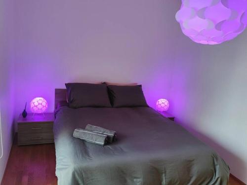 um quarto com uma cama com luzes roxas em Enjoy luxury and convenience @best area of Tallinn em Talin