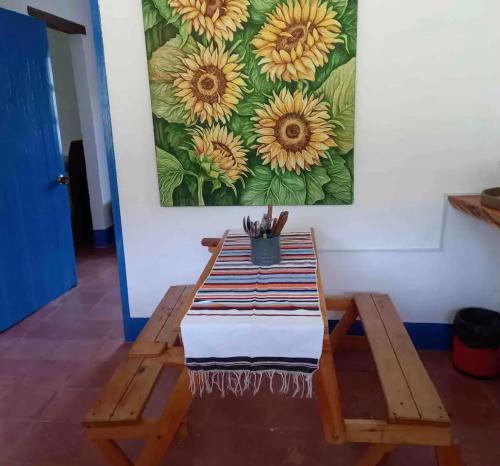 a bench with a painting of sunflowers on the wall at Hacienda San Francisco in Venecia