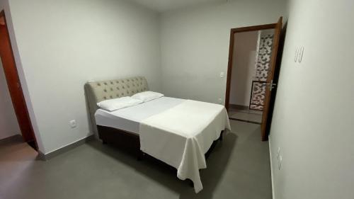 Dormitorio pequeño con cama y espejo en Casa 100m da praia em Arraial, en Porto Seguro