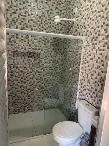 a bathroom with a toilet and a glass shower at Pousada Caminho do Paraiso in Maragogi