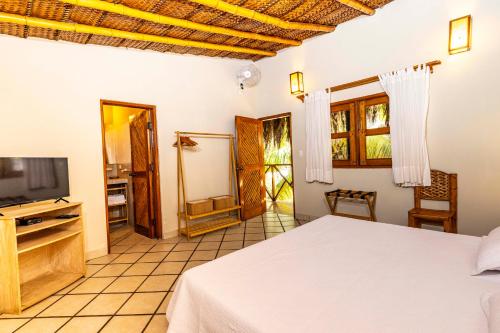 a bedroom with a bed and a flat screen tv at Las Olas in Máncora