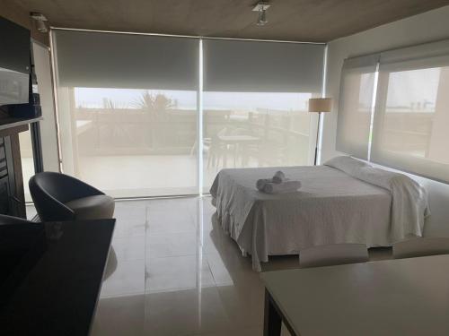 una camera da letto con un letto e una grande finestra di Linda Bay Resort y Spa Monoambiente a Mar de las Pampas