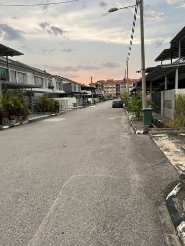 an empty street with houses and a car on the road at Havengate Homestay in Butterworth