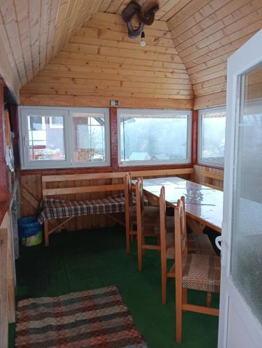 a dining room with a table and chairs in a cabin at Cabana Daria in Gîrda de Sus