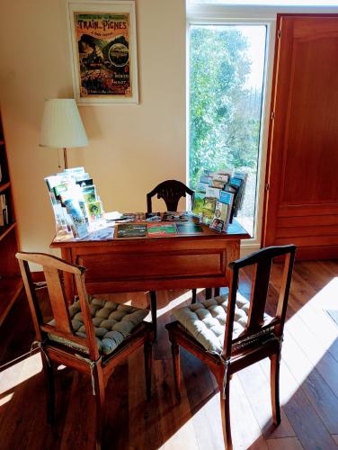 a room with a desk and two chairs and a window at La Mancellière de Montjoie chambres d'hôtes et gîtes in Saint-Michel-de-Montjoie