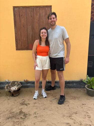 a man and a woman standing in front of a building at Dolphin Village in Kalpitiya