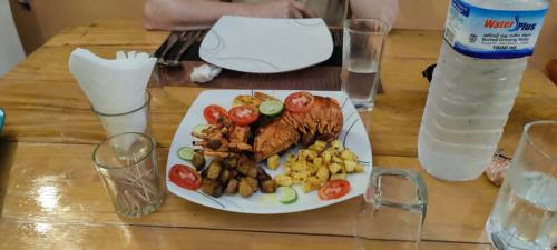 a plate of food with meat and vegetables on a table at Dolphin Village in Kalpitiya