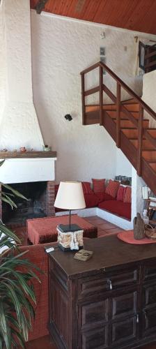 salon z czerwoną kanapą i schodami w obiekcie Butia Aguas Dulces w mieście Aguas Dulces