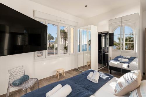 une chambre avec deux lits et une télévision à écran plat dans l'établissement 8H - Appartement Penthouse 4 chambres, à Cannes