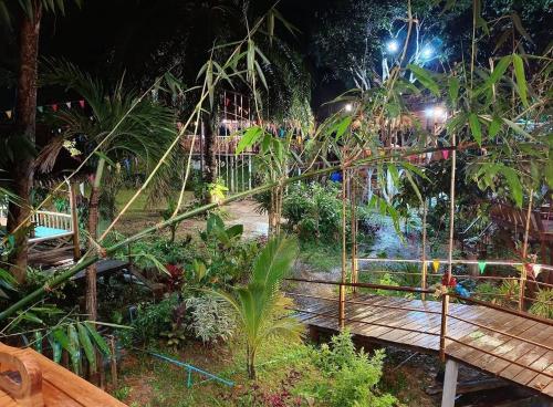 a garden at night with a wooden walkway at Rommai Forest Bungalows in Ko Lanta