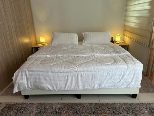 een slaapkamer met een groot bed met witte lakens en kussens bij Lovely Luxury in Kajang