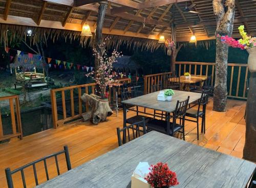 een restaurant met houten vloeren en tafels en stoelen bij Easy Life Country House in Koh Lanta