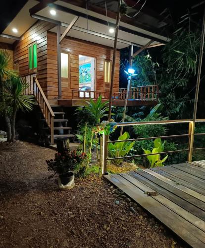 a wooden cabin with a porch at night at Rommai Forest Bungalows in Ko Lanta