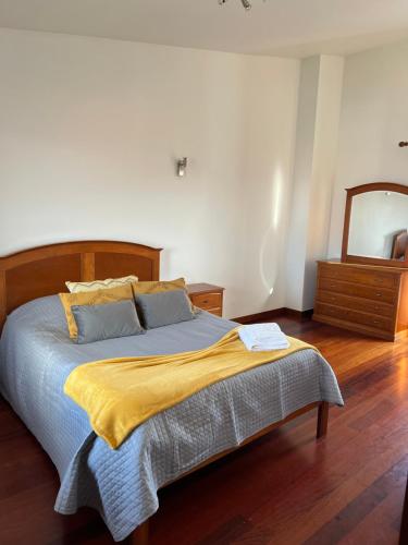 1 dormitorio con 1 cama con manta amarilla y espejo en SanMar, en Madalena