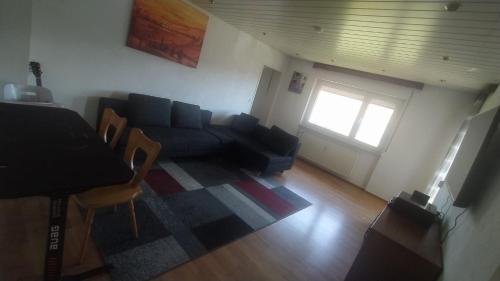 a living room with a couch and a table at Room in shared apartment in Friedrichshafen