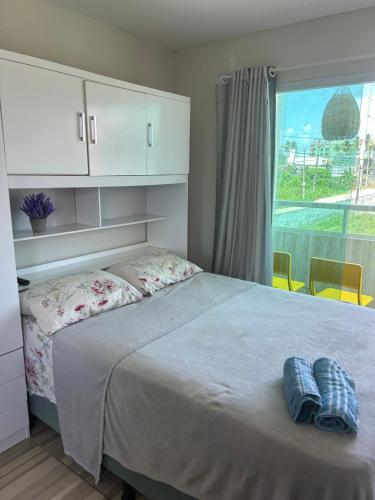 a bedroom with a bed with two blue towels on it at Studio A completo 400m da praia in Porto De Galinhas