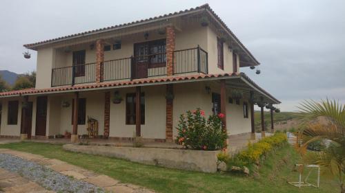 a white house with a balcony on top of it at Casa de Campo - Tinjaca Boyacá in Tinjacá