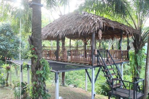 a gazebo with a thatch roof and a tree at Rommai Forest Bungalows in Ko Lanta