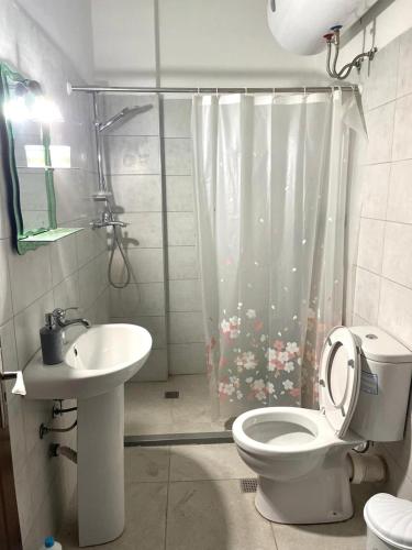 a bathroom with a toilet and a sink at Cozy Beachfront Room in Durrës