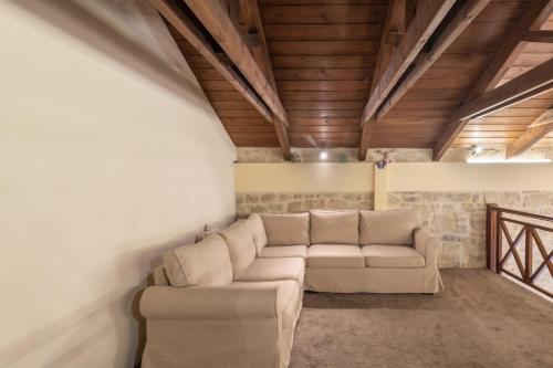 a living room with a couch and wooden ceilings at Villa Lambraki in Síva