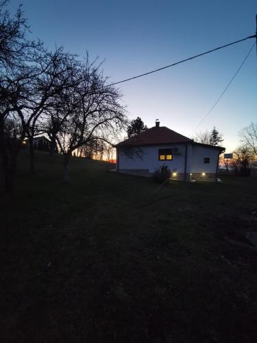 a house with its lights on in a field at Topola vikendica in Topola