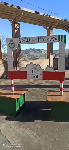 a bus stop with two benches and a sign at B&B Monzuno-Sulla Via degli Dei in Monzuno