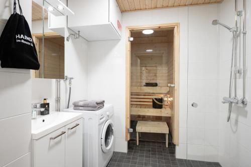 a bathroom with a washing machine and a shower at Premier Homes Pori Center Jazz in Pori